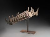 sculpture représentant une tête de poisson posée sur un socle, sur fond gris