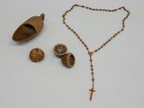 une photo représentant un chapelet, des perles en bois et une cuillère en bois posés sur une table