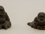 pair of small bronze figurines of a boy and a girl sitting on the ground