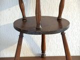 une petite table en bois à deux pieds posée sur un parquet
