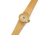 une image d'un gros plan d'une montre-bracelet sur une surface blanche