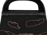 a black handbag with a drawing of a cat on it