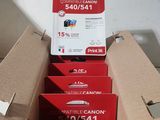 six canon ink cartridges in a cardboard box sitting on top of each other