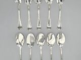 six spoons and two spoons are lined up on a table
