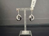 a pair of earrings that are on display on a stand