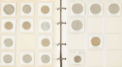 un livre ouvert sur lequel sont posées plusieurs pièces de monnaie différentes