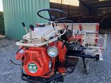 a small red tractor parked in front of a building
