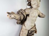 a small statue of a child hanging from a chain