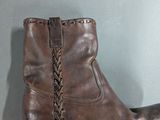 brown leather cowboy boots with braids on the side of them