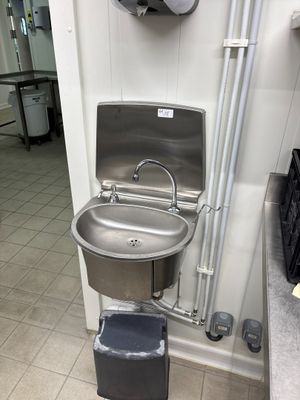 un lavabo et une poubelle dans des toilettes publiques
