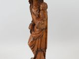 an old wooden statue of a woman holding a child
