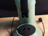 une cafetière verte posée sur une table en bois
