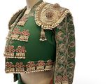 a close up of a mannequin wearing a green and gold outfit