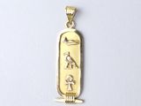 an image of a gold pendant with an egyptian symbol on it