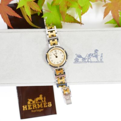an image of a watch sitting on top of a box next to a plant