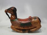 a small wooden horse with a saddle on it ' s back