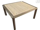 La table est en bois et possède un piètement en métal.