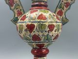 a vase with a floral design on it on a stand