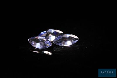 a pair of blue sapphires sitting on top of a black surface