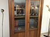 a tall wooden cabinet with many books on it
