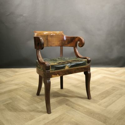 une chaise en bois avec une assise en cuir, posée sur un parquet