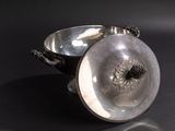 a silver bowl sitting on top of a black table