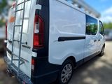 a white van parked in a parking lot with a ladder on the back of it