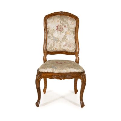 une image d'une chaise en bois dont l'assise est recouverte d'un rembourrage floral