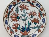 a plate with a floral design on it on a white surface