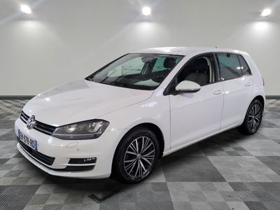 Une Volkswagen Golf blanche est garée sur un sol à damier.