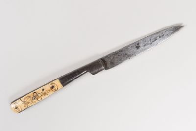 a knife that is laying on a white surface