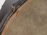 a small lizard sitting on top of a drum