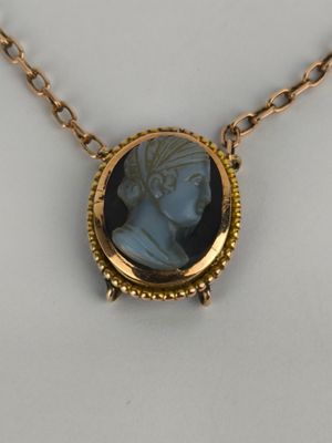 a close up of a necklace with a picture of a woman on it