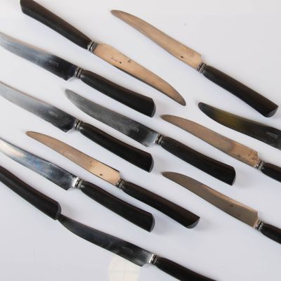 a lot of knives that are on a white surface