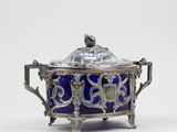 an antique silver and blue glass covered dish with a bird on top