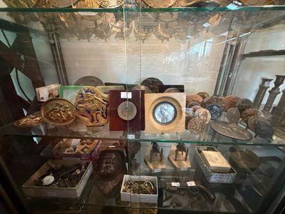 une vitrine en verre contenant une horloge et d'autres objets