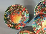 three colorful plates with designs on them are sitting on a table