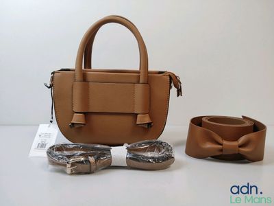 un sac à main et une ceinture posés sur une table, à côté d'une paire de lunettes