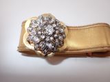 a close up of a gold belt with a flower on it