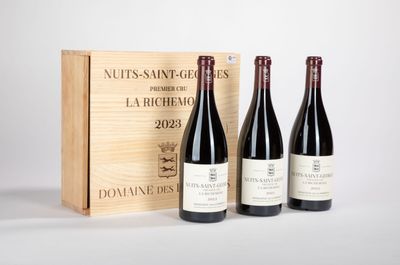 trois bouteilles de vin devant une caisse en bois