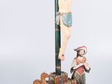 a statue of jesus on the cross with a man and a dog