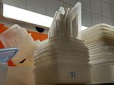 a stack of plastic containers sitting on a shelf in a kitchen