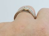 a woman ' s hand with a diamond ring on her finger