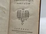 un livre ouvert sur lequel figure un blason