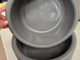 une personne tenant un bol et un bol posé sur une table