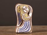 a small ceramic figurine of a woman on a table