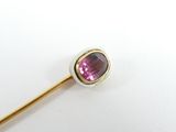 gold and pink tourmaline broochle pin on a white surface