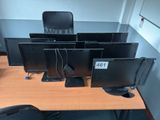 four computer monitors sitting on a desk in an office