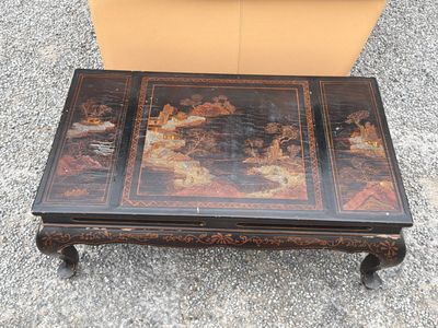 a coffee table with a painting on the top of it