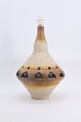 a brown and white vase with holes on it